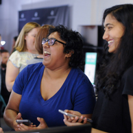 two women holding phones and laughing