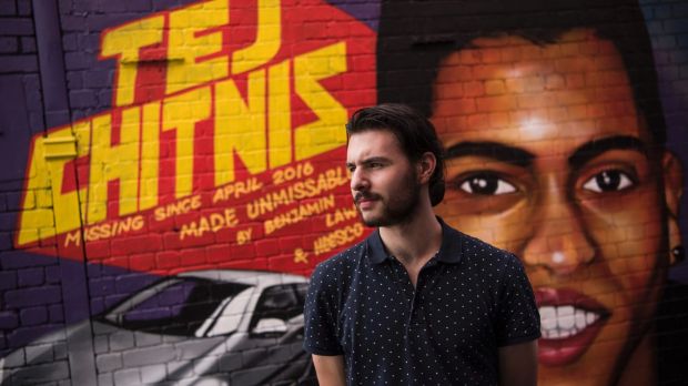 Man stands in front of mural